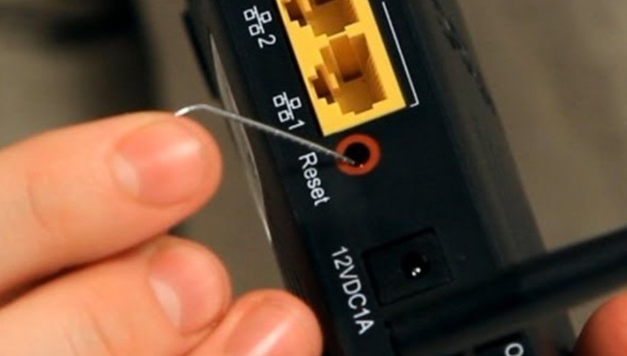 Pressing the reset button with a paperclip