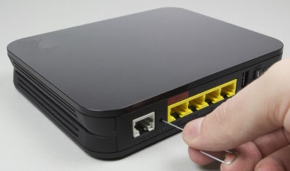 Holding the reset button on the back panel